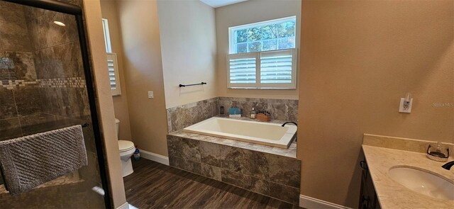 full bathroom with vanity, a bath, wood finished floors, a shower stall, and toilet