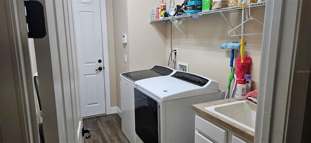 laundry area featuring laundry area, dark wood-style flooring, a sink, and separate washer and dryer