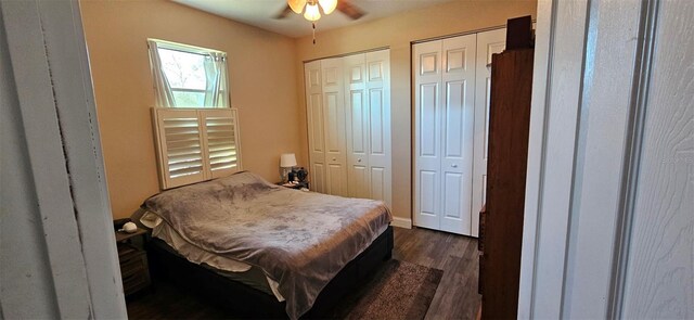 bedroom featuring a ceiling fan, multiple closets, and dark wood-style flooring