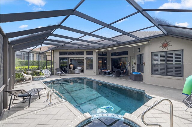 view of pool with glass enclosure and a patio