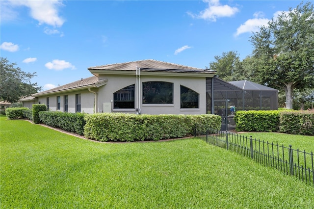 view of property exterior featuring a yard and glass enclosure