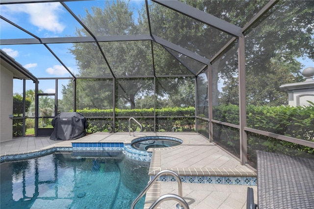 view of pool with an in ground hot tub, glass enclosure, and area for grilling