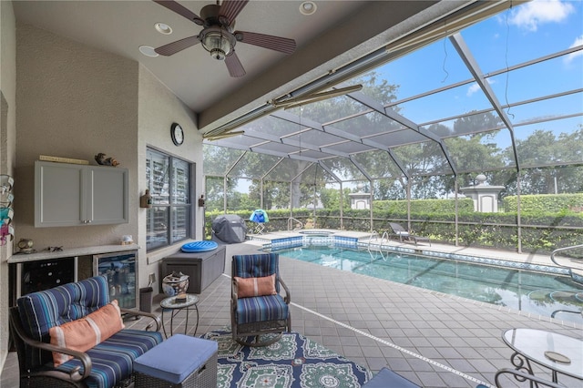 view of pool with glass enclosure, ceiling fan, and a patio area