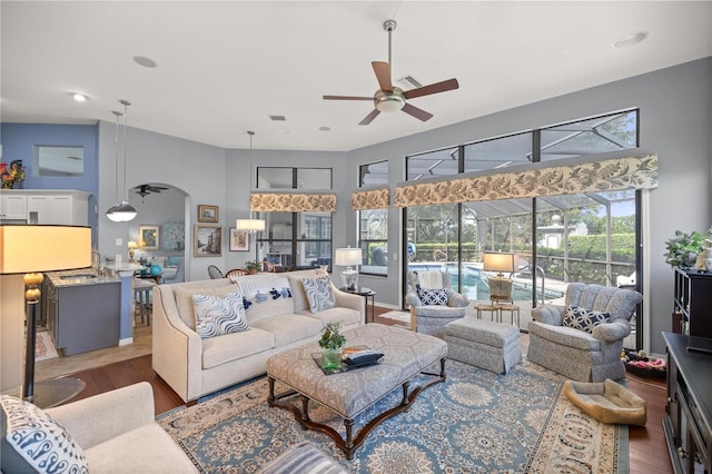 living room with dark hardwood / wood-style flooring, ceiling fan, and sink