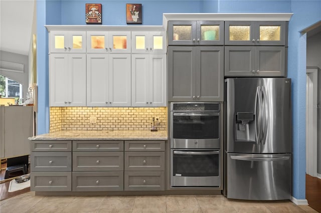 kitchen with backsplash, stainless steel appliances, white cabinetry, and gray cabinetry