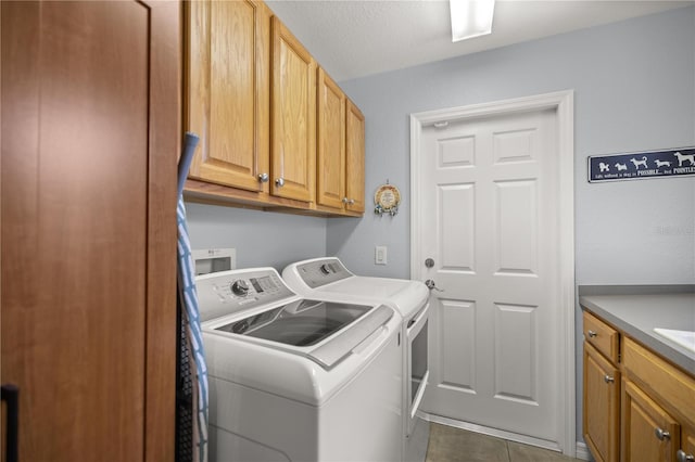 laundry area with cabinets, dark tile patterned flooring, and independent washer and dryer