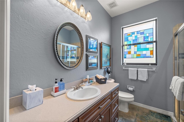 bathroom with vanity, toilet, and an enclosed shower