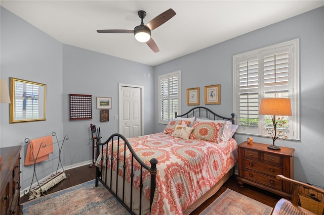 bedroom featuring hardwood / wood-style flooring, ceiling fan, multiple windows, and a closet