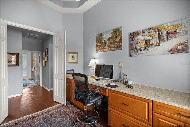 home office with dark hardwood / wood-style flooring