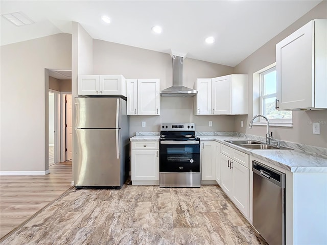 kitchen featuring stainless steel appliances, wall chimney exhaust hood, and white cabinetry