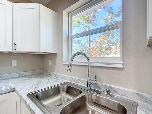 interior details with white cabinetry and sink