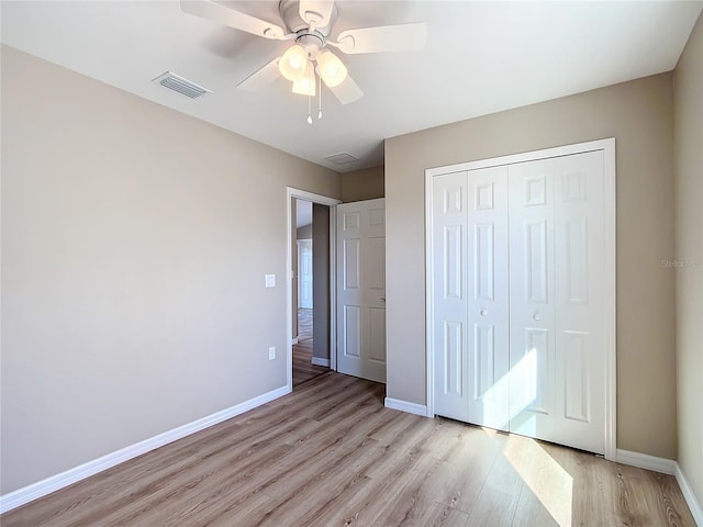 unfurnished bedroom with ceiling fan, light hardwood / wood-style flooring, and a closet