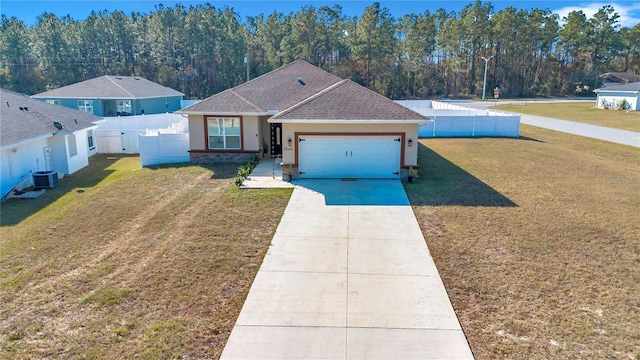 view of front of home featuring central air condition unit, a garage, fence, concrete driveway, and a front yard