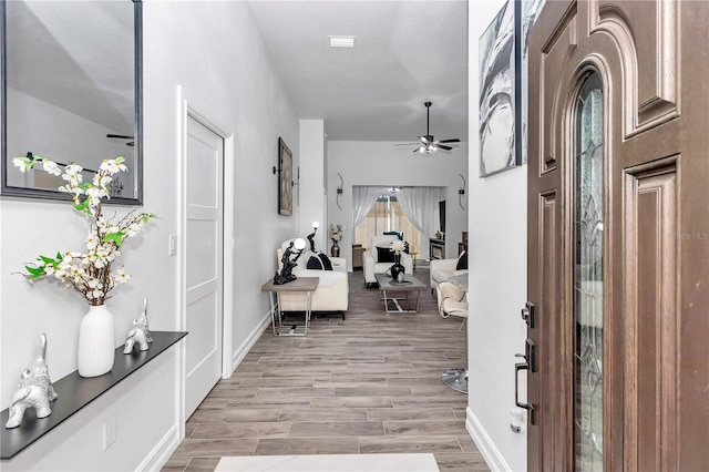 entryway with wood finish floors, ceiling fan, and baseboards