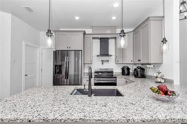 kitchen featuring stainless steel appliances, wall chimney exhaust hood, gray cabinets, and pendant lighting