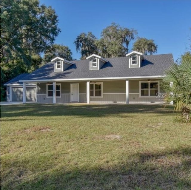 view of front of house with a garage, a front yard, and a porch