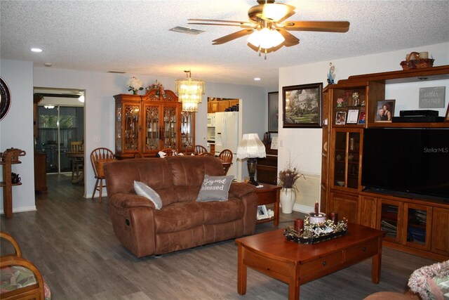 living room with ceiling fan with notable chandelier, a textured ceiling, and hardwood / wood-style flooring