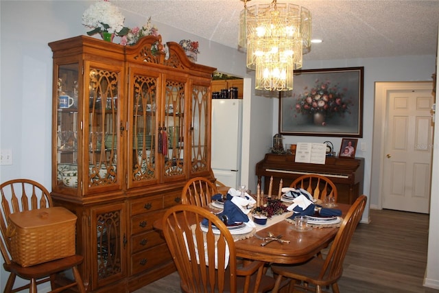 dining area featuring a textured ceiling, a chandelier, and dark hardwood / wood-style floors