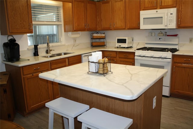 kitchen with white appliances, a kitchen bar, dark hardwood / wood-style flooring, and sink