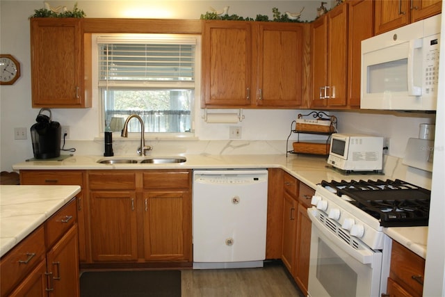 kitchen featuring white appliances, sink, and wood-type flooring