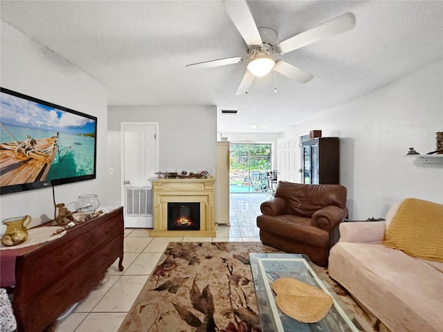 tiled living room with a textured ceiling and ceiling fan