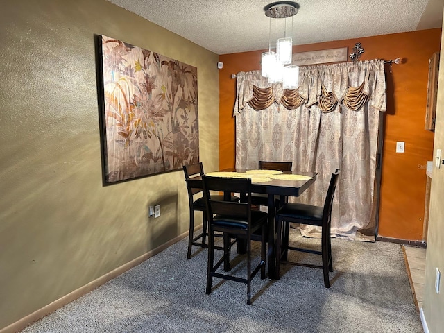 carpeted dining space featuring a chandelier and a textured ceiling