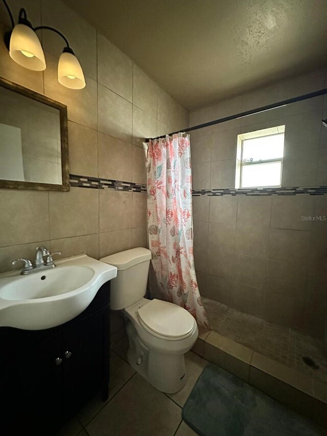 bathroom featuring toilet, a shower with curtain, tile walls, and vanity