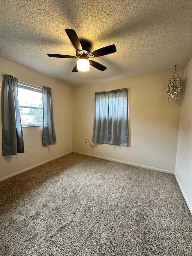 carpeted spare room with ceiling fan and a textured ceiling