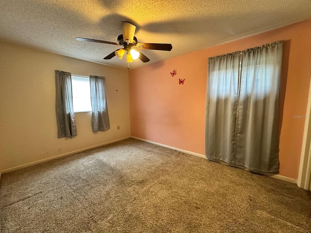 empty room featuring a textured ceiling, ceiling fan, and carpet