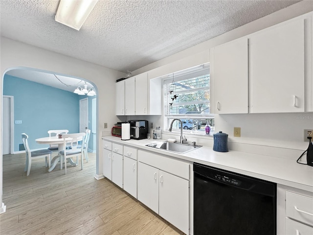 kitchen featuring white cabinets, black dishwasher, light hardwood / wood-style floors, sink, and a notable chandelier