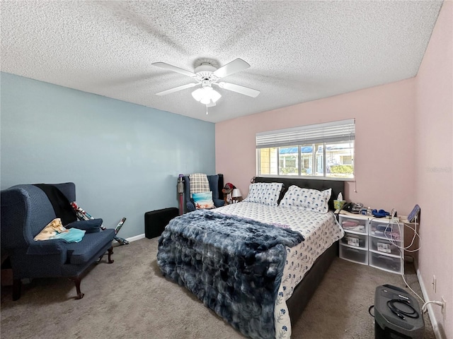 bedroom with ceiling fan, carpet floors, and a textured ceiling