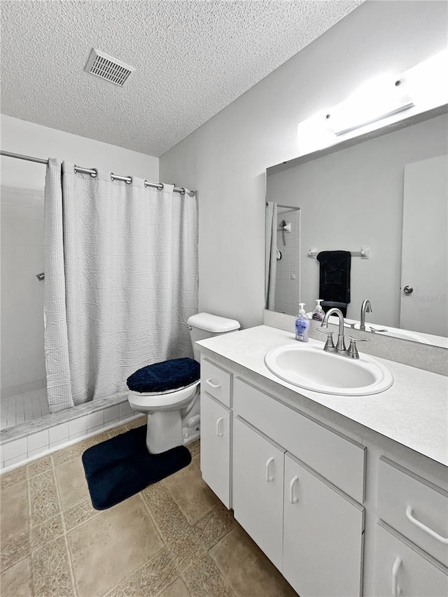 bathroom featuring a textured ceiling, toilet, vanity, and a shower with curtain