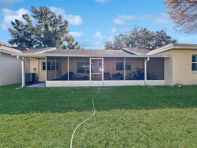 rear view of house featuring central AC, a sunroom, and a lawn