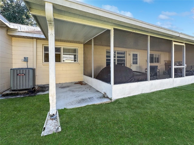 exterior space with a lawn, central AC, and a sunroom