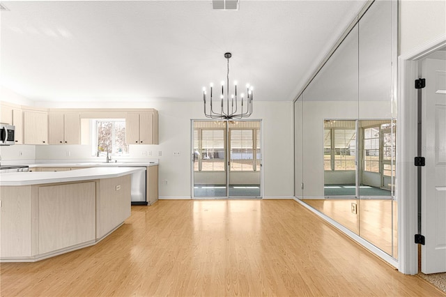 kitchen featuring light hardwood / wood-style floors, hanging light fixtures, a chandelier, and appliances with stainless steel finishes