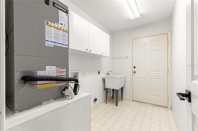 laundry room with electric dryer hookup, cabinets, washer hookup, a textured ceiling, and heating unit