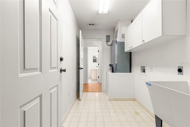 clothes washing area featuring cabinets, sink, washer hookup, a textured ceiling, and hookup for an electric dryer