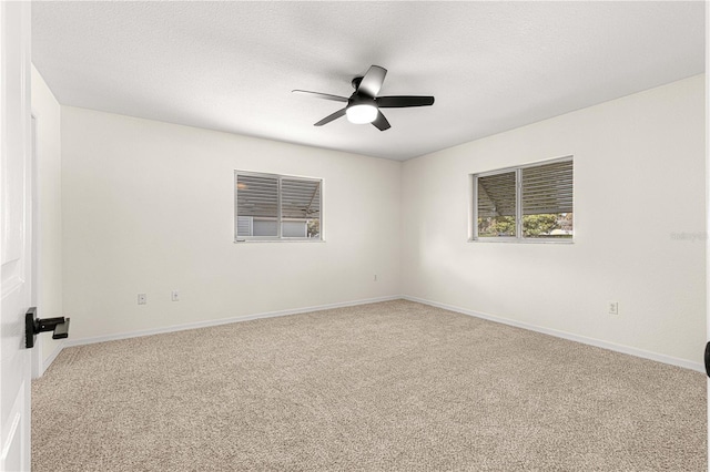 carpeted spare room with ceiling fan and a textured ceiling