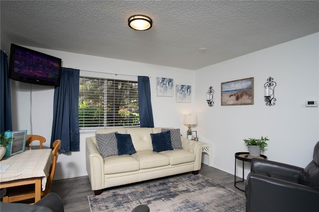 living room featuring dark hardwood / wood-style floors and a textured ceiling