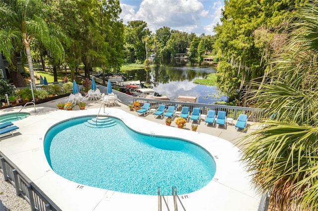 view of swimming pool with a water view and a patio