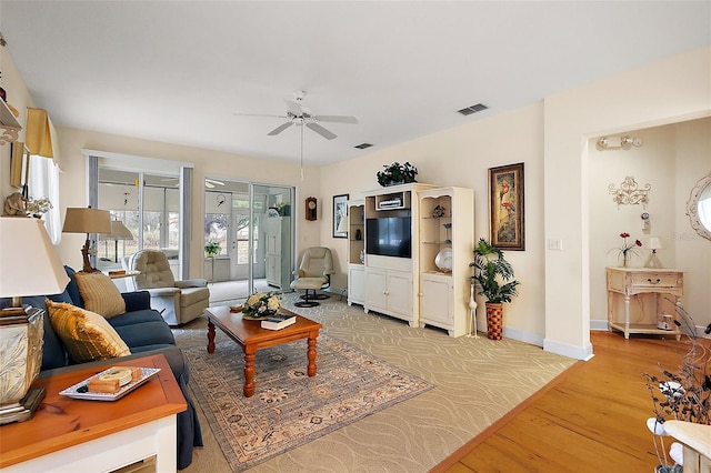 living room featuring ceiling fan and light hardwood / wood-style flooring