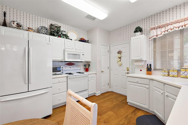 kitchen featuring white appliances, light hardwood / wood-style floors, backsplash, white cabinets, and sink