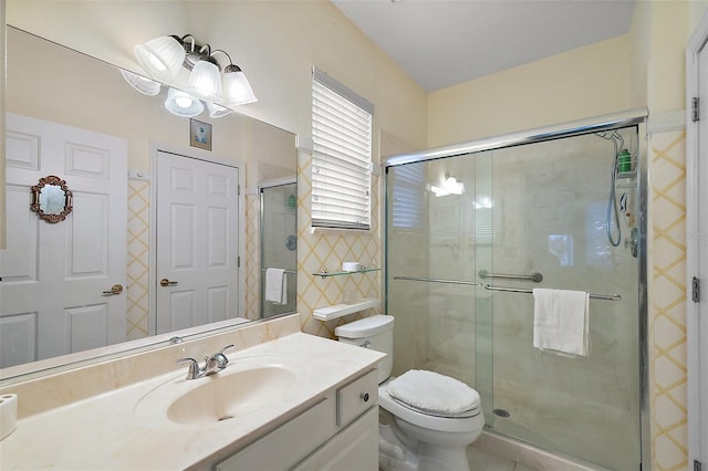 bathroom featuring vanity, a shower with shower door, and toilet