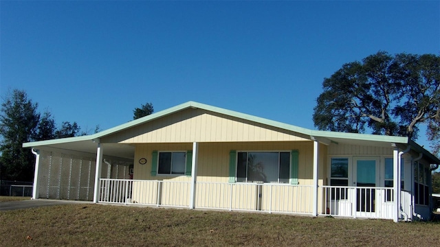 back of property with a yard and a carport