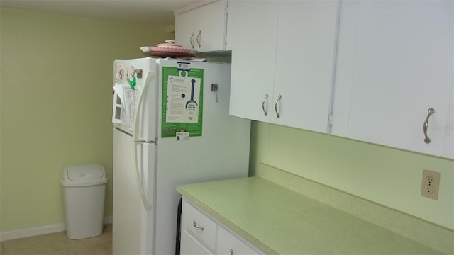 kitchen with white cabinetry, white fridge, and light tile patterned flooring