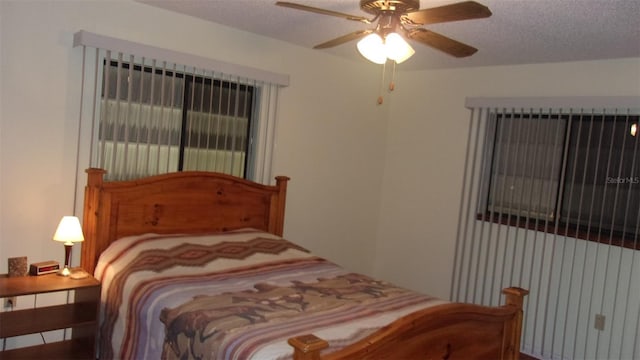 bedroom with ceiling fan and a textured ceiling