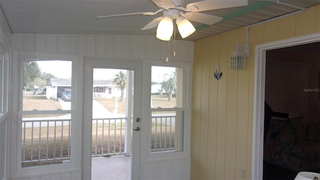 entryway with wooden walls and ceiling fan