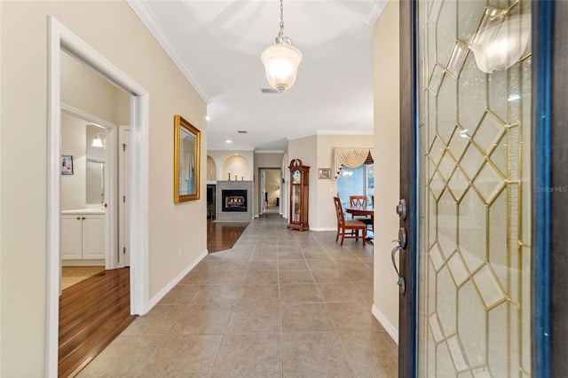 entrance foyer featuring crown molding and light tile patterned floors