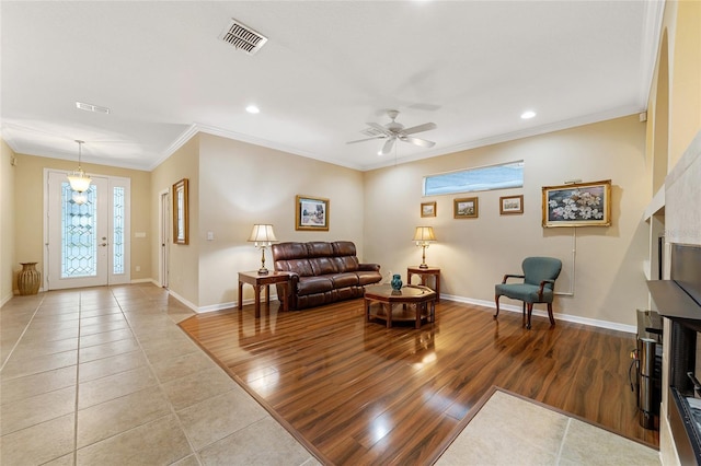 living room with hardwood / wood-style flooring, ornamental molding, and ceiling fan