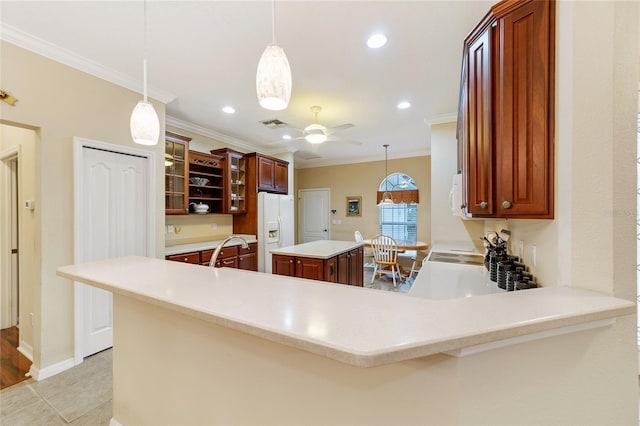 kitchen with pendant lighting, white fridge with ice dispenser, a center island, and kitchen peninsula